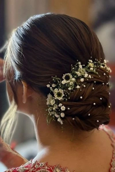 sleek low bun with floral accessories hairstyle